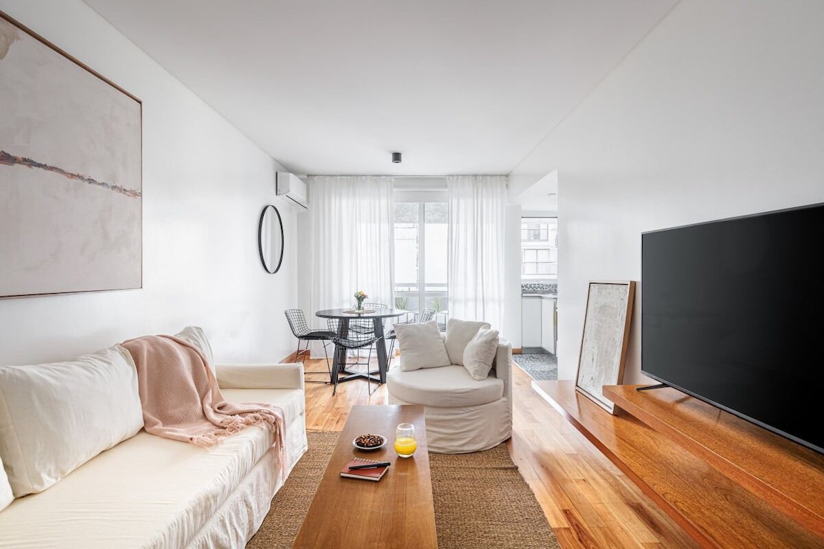 Un salon moderne avec un canapé, une table basse et un téléviseur à écran plat.