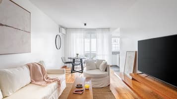 Uma sala de estar moderna com sofá, mesa de centro e televisão de tela plana.