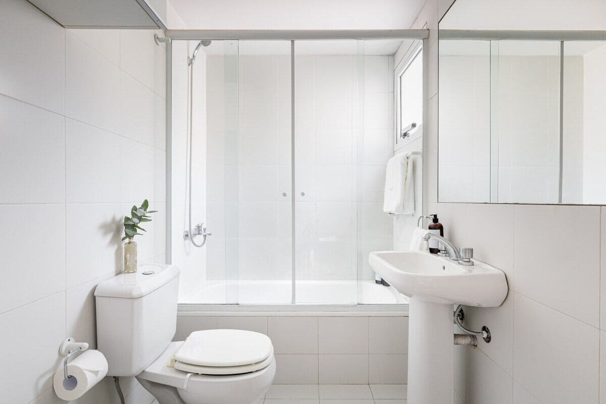 Un baño moderno con inodoro, lavamanos y ducha.