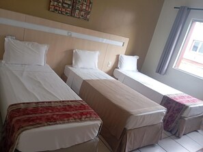 A hotel room with two single beds, a small table, and a window with curtains. - Enjoy a Relaxing Stay in a Serene Room w/ Easy Access to Outdoor Pool & Lake (Pará)