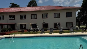 Une piscine avec un bâtiment en arrière-plan.