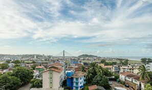 Un paisaje urbano costero con un puente atirantado destacado, edificios residenciales y vista al mar.