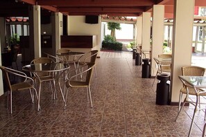 An outdoor patio area with wicker furniture, a tiled floor, and a view of the outdoors. - Calm, Relaxing Space w/ Outdoor Pool Access - Perfect for Couples to Unwind (Pará)