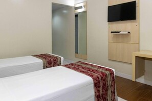 A hotel room with two single beds, a mirror, a TV mounted on the wall, and a small wooden desk. - Calm, Relaxing Space w/ Outdoor Pool Access - Perfect for Couples to Unwind (Pará)