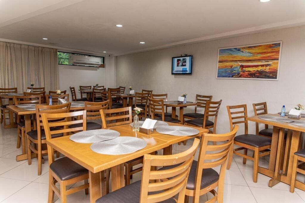 A dining area with wooden tables and chairs, arranged in a spacious layout.