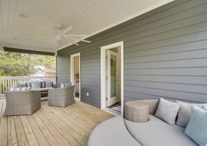 A covered porch with wicker furniture, a ceiling fan, and a grey exterior wall. - Lucky Snapper - 30A Coastal Retreat with 6-Seater Golf Cart (Santa Rosa Beach)