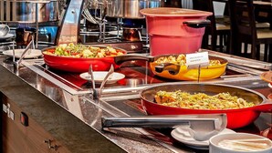 Disposição de buffet com diversos pratos e equipamentos de cozinha.