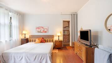 Une chambre d’hôtel avec un grand lit, des lampes de chevet, une télévision et un tableau au mur.