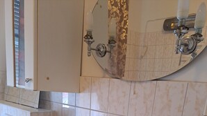 Ein Badezimmer mit einem weißen Waschbecken, einer schwarzen Arbeitsplatte und einem Spiegel darüber.