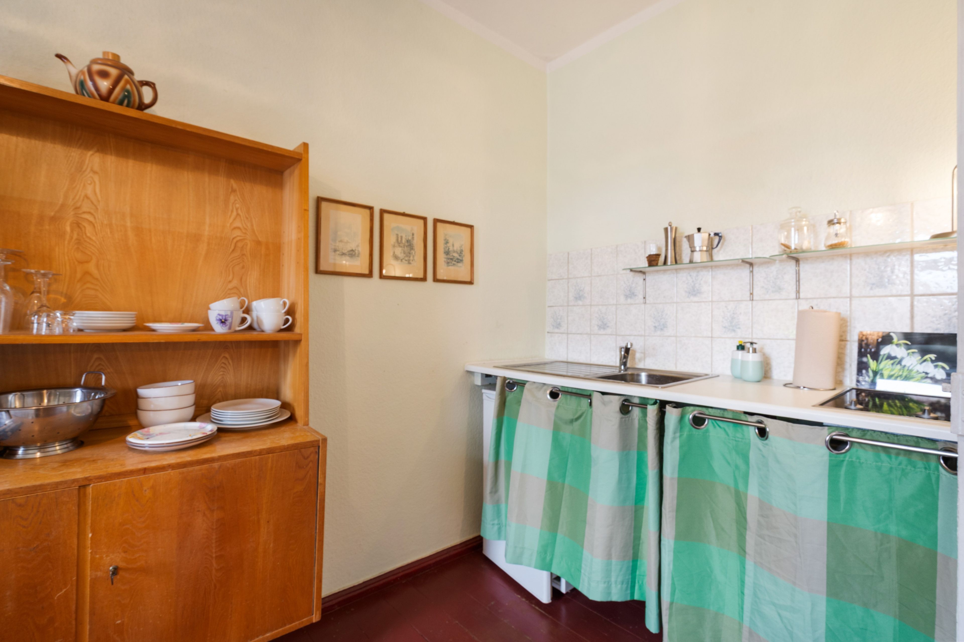 Una cocina con gabinetes de madera, un lavamanos y salpicadero de azulejos.