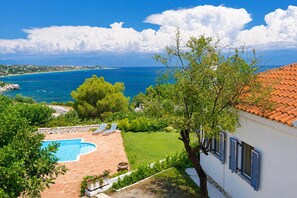 Une propriété résidentielle dotée d’une piscine, d’un jardin et offrant une vue sur la mer.