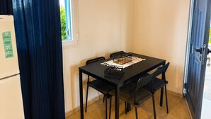 Ein kleiner Essbereich mit Tisch, Stühlen und einem Fenster.