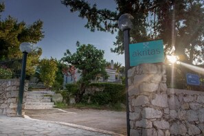 A stone wall with a sign for 'akritas' and a lamp post. - Koroni Akrita Residence, Sfaktiria Pooliside Nest (Koroni)