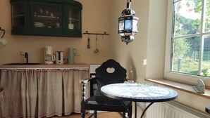 A kitchen with a wooden table, a cabinet, and a hanging lantern.
