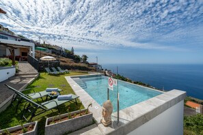 Ein Pool mit Blick auf den Ozean, eine Buddha-Statue und ein Schild mit der Aufschrift 'Nicht schwimmen'.