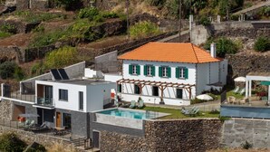 Ein modernes Haus mit Swimmingpool, Steinmauern und Garten.
