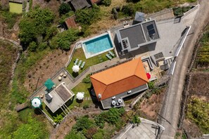 An aerial view of a property with a swimming pool, outdoor seating, and a covered patio area. - Tranquil with seaview|Ocean Hills Garden Studio (Faja Da Ovelha)