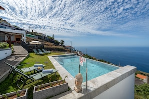 A pool with a view of the ocean, a Buddha statue, and a no swimming sign. - Tranquil with seaview|Ocean Hills Terrace Studio (Faja Da Ovelha)