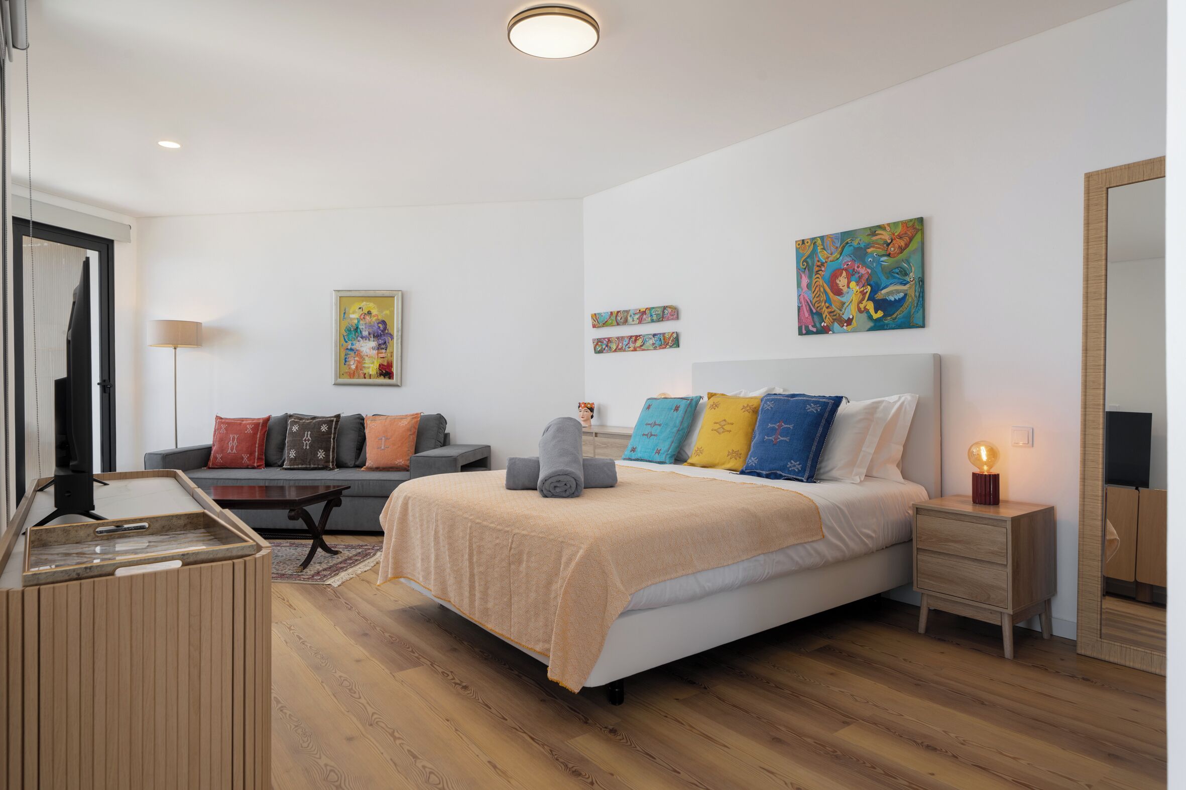 Une chambre à coucher moderne avec un lit, une table de chevet et un téléviseur.