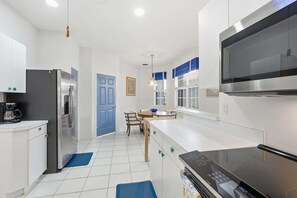 A modern kitchen with a built-in microwave, a refrigerator, and a stove. - Villa With Lake and Golf Views on Public Arrowhead Golf Course (Naples)