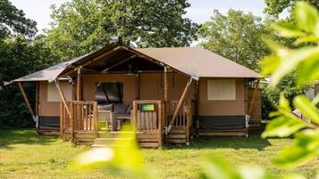Eine einstöckige Holzhütte mit Veranda, einer kleinen Sitzecke und einem Schild, das ein Badezimmer anzeigt.