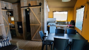 A rustic cabin interior with a dining area, kitchen, and sleeping quarters. - Vacation home by Interhome (Osecná)