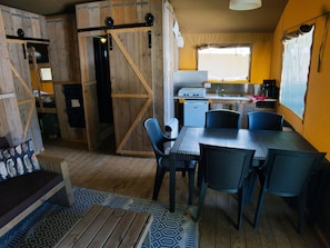 Ein rustikales Blockhaus-Interieur mit Essbereich, Küche und Schlafkammern.