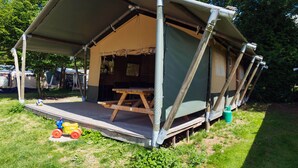 A tented camping area with a picnic table, surrounded by greenery and trees. - Vacation home by Interhome (Osecná)