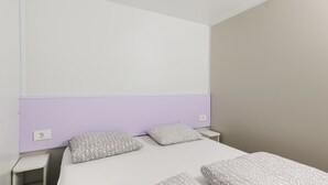 Een slaapkamer met een bed, twee nachtkastjes en een hoofdbord.