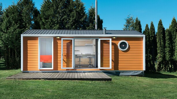 A modern, single-story cabin with a large sliding door, a small porch, and a chimney. - Vacation home by Interhome (Osecná)