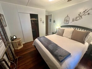 Ein Schlafzimmer mit einem Bett, einem Nachttisch, einer Lampe und einem Kleiderschrank.
