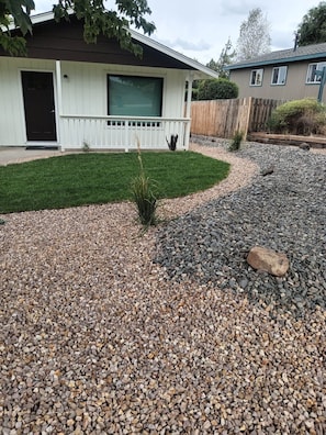 Il s'agit d'une propriété résidentielle dotée d'un jardin devant la maison, comprenant un chemin de gravier, un petit arbuste et une pelouse bien entretenue.