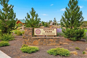 Un panneau indiquant l’entrée du parc Quartz, situé dans la ville de Redmond, entouré d’arbres et à proximité d’une aire de jeux.