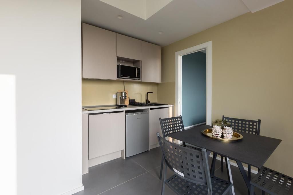 A compact kitchen with a microwave, dishwasher, and a dining area with a table and chairs.