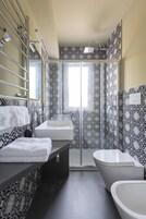 Un baño con ducha, dos lavamanos y paredes con diseño.