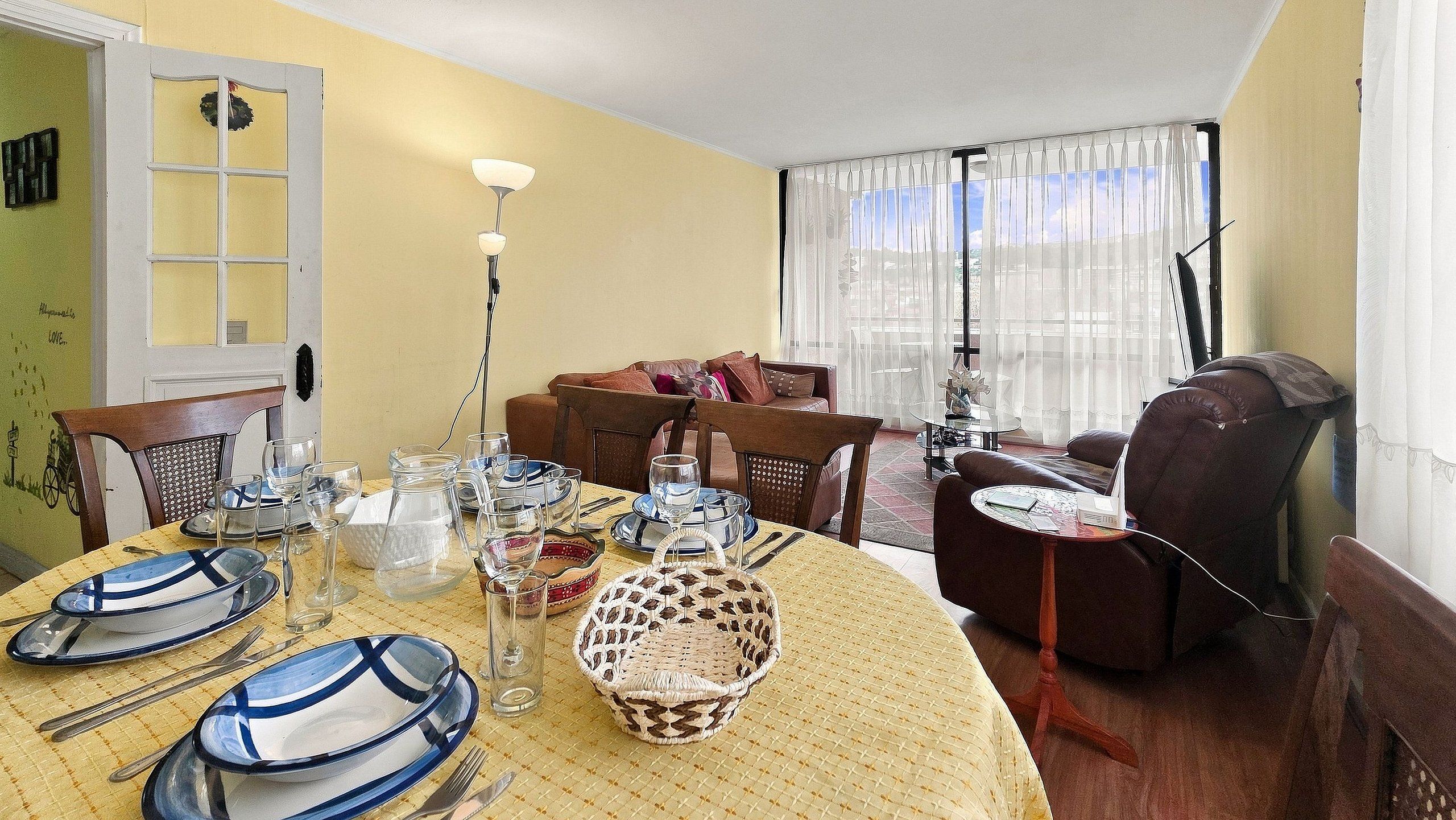 Comedor con una mesa redonda dispuesta para cuatro personas, rodeada de sillas.