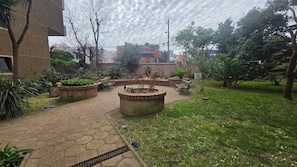 Un pati amb un camí empedrat, bancs i jardineres.
