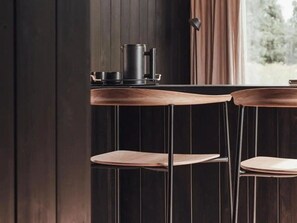Un espace bar avec deux tabourets de bar en bois et un comptoir de bar en métal.