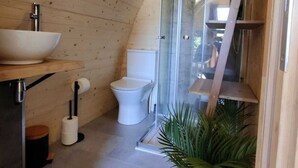 A compact bathroom with a wooden ceiling, a sink, toilet, and a shower enclosure. - Wilsumer Berge Resort - Wood Lodge by Interhome (Wilsum)