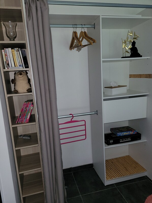 A room with a wardrobe containing shelves, a hanging rod, and a shoe rack. - Gîte du Hérisson, 40 m², with a garden, near animal parks and Disney, in a quiet location (Pommeuse)