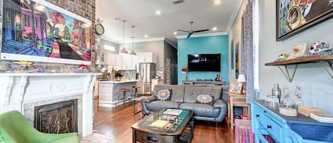 A modern living room with a fireplace, a sofa, a coffee table, and a TV.