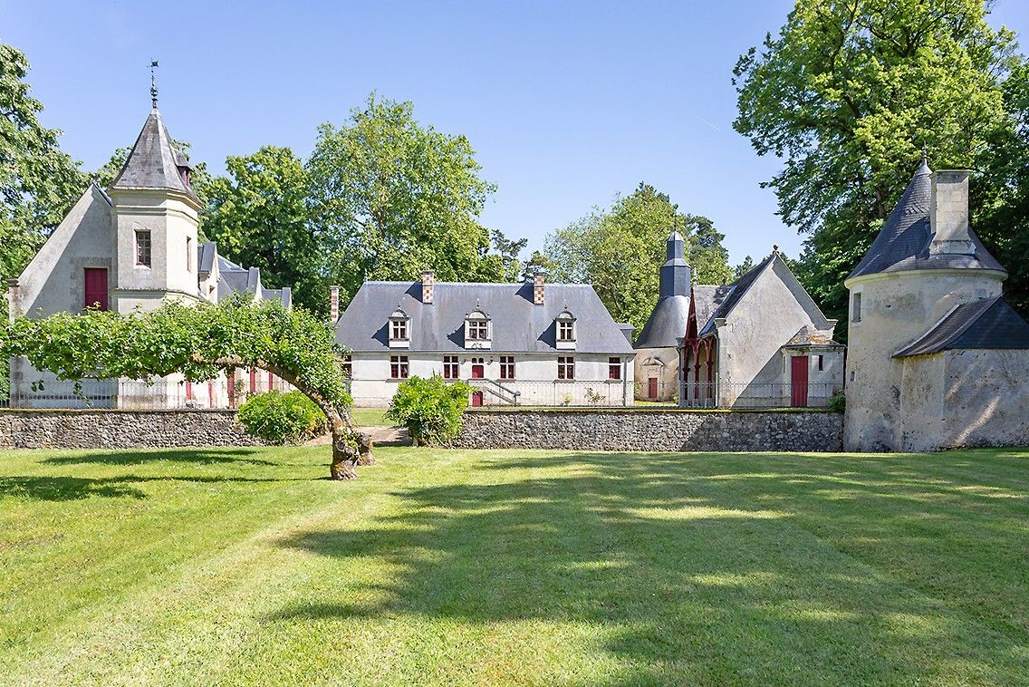 A large estate with multiple buildings, including a prominent tower and a main house with a steep roof.
