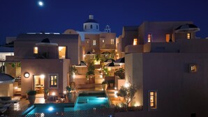 Un hotel con piscina, varias construcciones y un cielo nocturno.