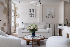 Un salon moderne avec un canapé, une table basse et des œuvres d’art accrochées aux murs.
