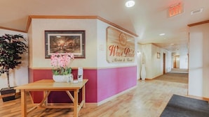 Uma área de recepção com uma mesa de madeira, um quadro emoldurado e uma placa indicando 'Wave Pointe Marina & Resort'.