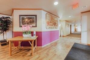 A reception area with a wooden desk, a framed picture, and a sign for 'Wave Pointe Marina & Resort'. - Wave Pointe Marina and Resort (Sturgeon Bay)