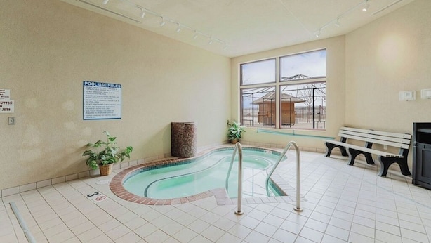 Piscina interna com um banco e uma placa na parede.