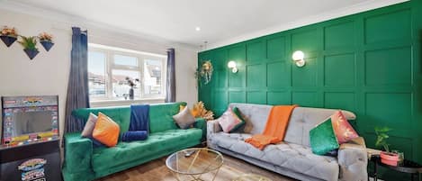 A living room with two sofas, a coffee table, and a gaming console.
