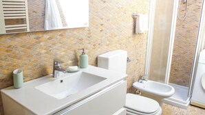 A bathroom with a white sink, a toilet, and a shower area. - Family-friendly apartment in Ravenna's historic center near UNESCO monuments (Ravenna)