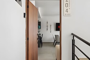 Ein modernes Interieur mit einer Holztür, einer Treppe und einem an der Wand befestigten Schild mit Nummern.